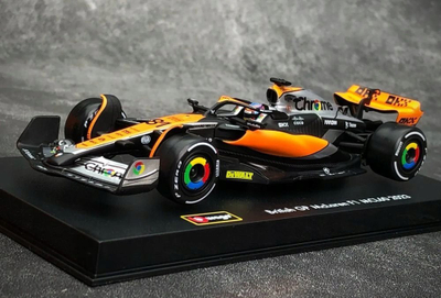 Maket makine F1 Bburago McLaren MCL60 2023 Oscar Piastri, shkalla 1:43, me helmetë, portokalli e zezë
