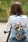 Çantë shpine për kalamaj Nici Travel Friends, me lodër rakun pelush, 25 cm, blu e çelët