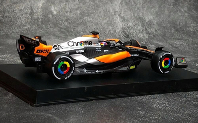 Maket makine F1 Bburago McLaren MCL60 2023 Oscar Piastri, shkalla 1:43, me helmetë, portokalli e zezë